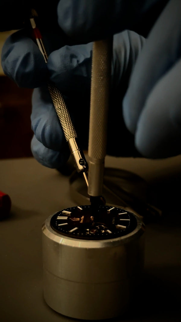Setting the hands with a tool under magnification